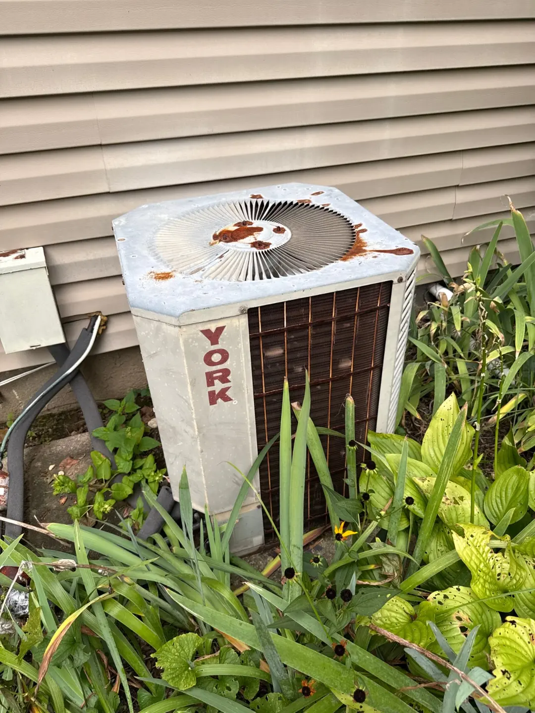 Older outdoor condenser beside a Melville home